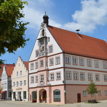 Altes Rathaus in Geisenfeld. Rosa- weißes Barockgebäude mit Stuckfigur an der Fassade