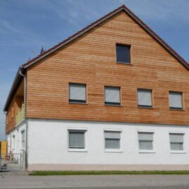 Wohnhaus mit Aufstockung, die mit Holz eingekleidet ist