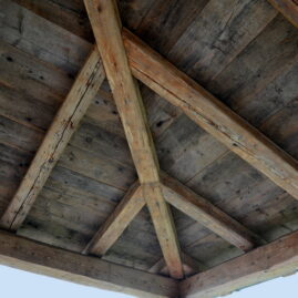 Detail einer Terrassenüberdachung mit Balken aus Altholz.