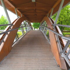 Bild einer Fußgängerbrücke aus Holz und Metall über die Paar in Rechertshofen. Sonderbau der Zimmerei Steinberger